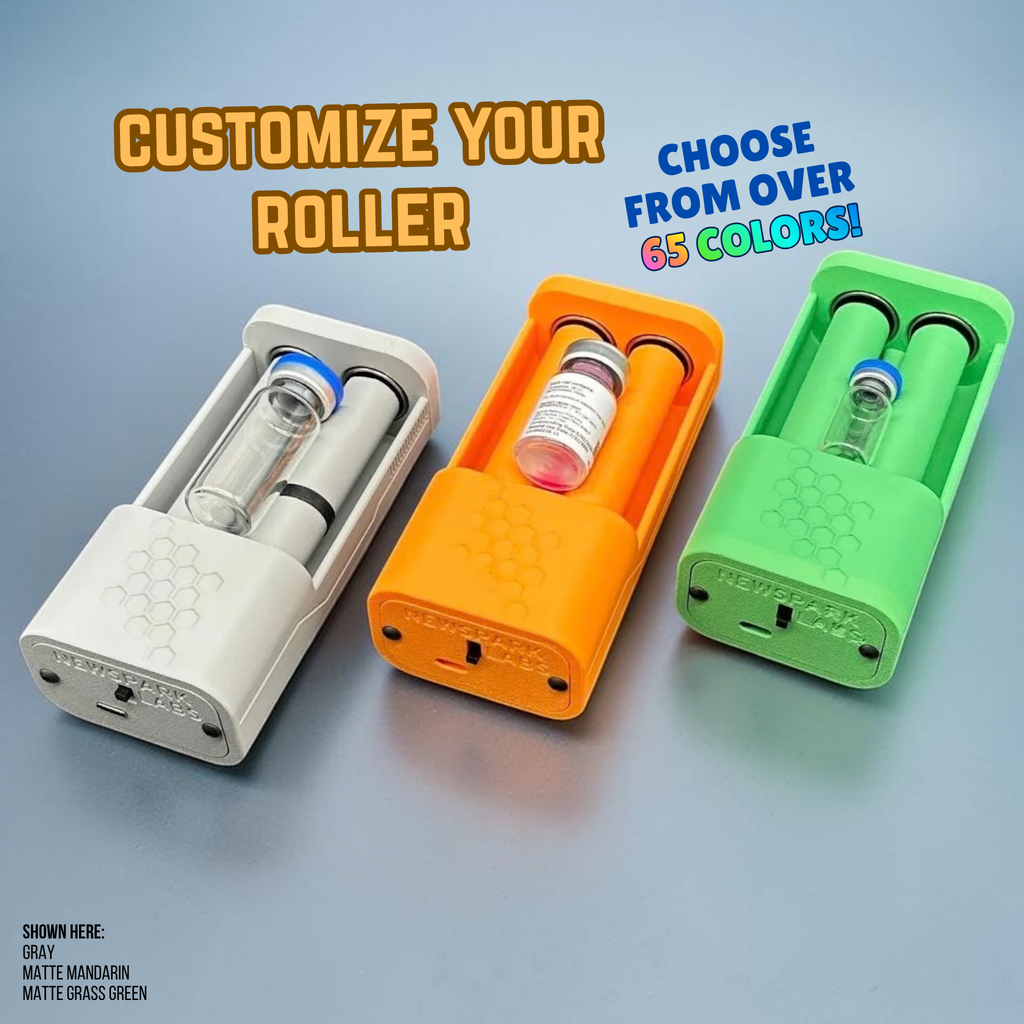 Three open, motorized, vial roller holders in different colors (matte gray, matte mandarin orange, and matte grass green). Each device shows a vial nestled between two rollers. The vials are three different sizes. There is promotional text overlays 'CUSTOMIZE YOUR ROLLER' and 'CHOOSE FROM OVER 65 COLORS!'