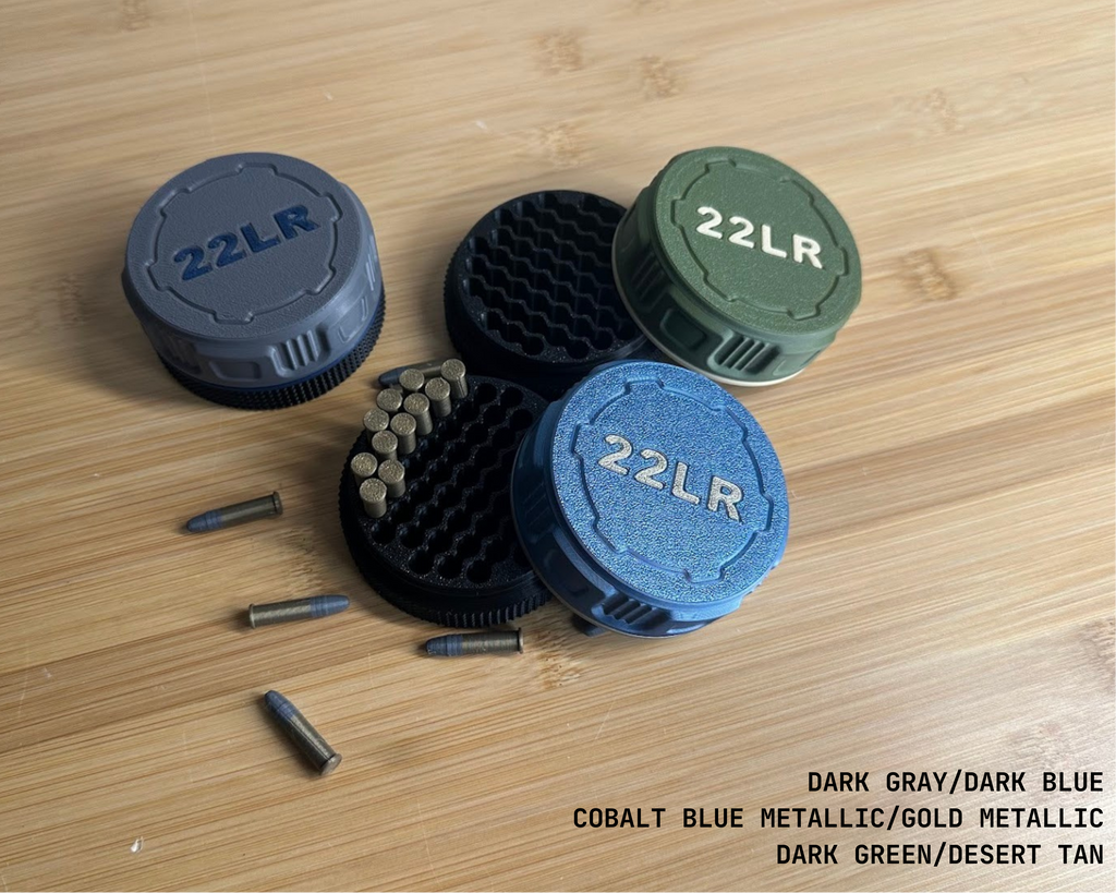 Three ammo pucks in different colors with '22LR' text on a wooden surface.