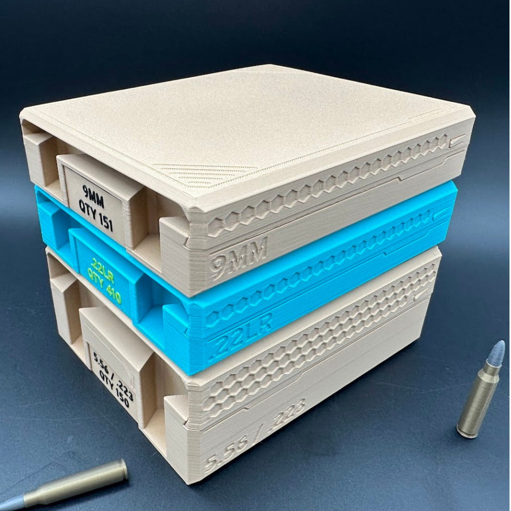 Stack of tan and turquoise ammunition organizer trays with two imitation bullets nearby on a dark background