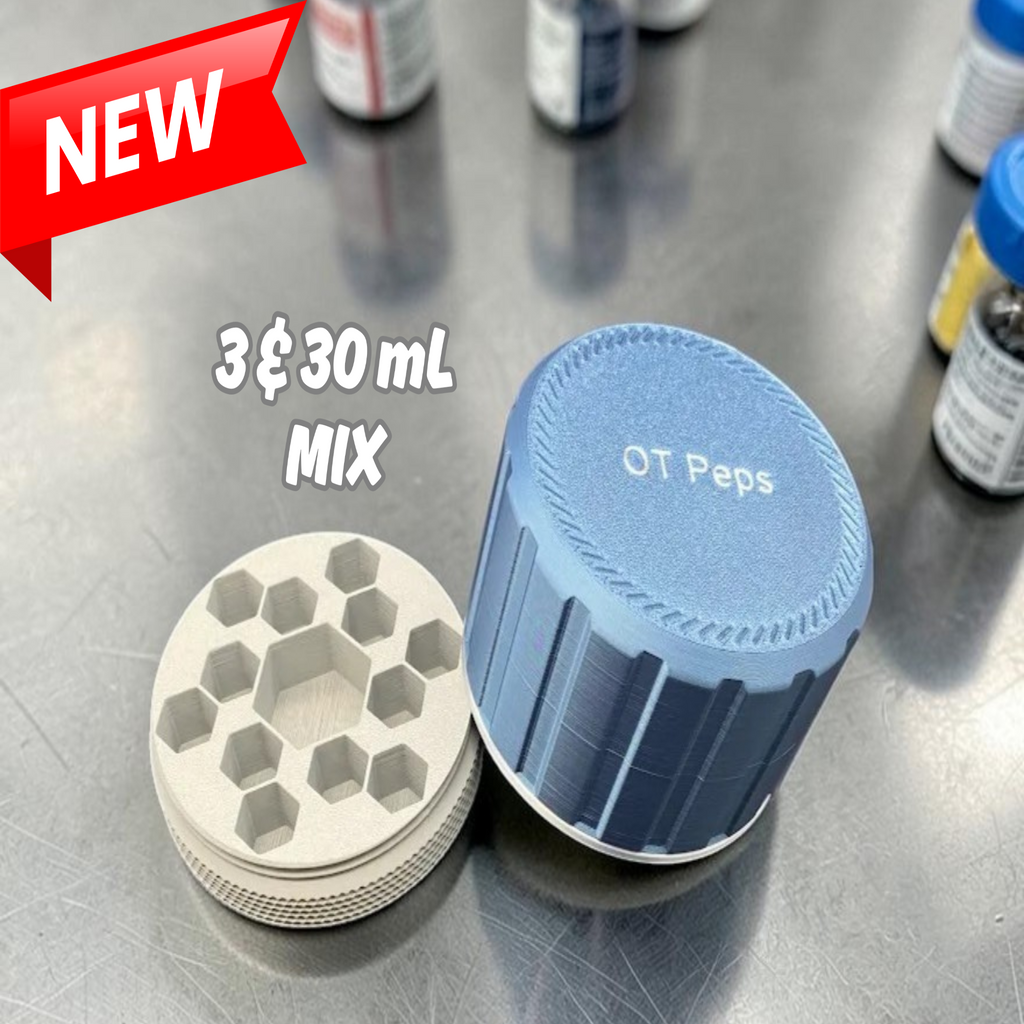 A 30 mL medication vial organizer shown open on a stainless steel surface, with a red 'NEW' banner and white text reading '3 & 30 mL MIX' overlaid on the image. The organizer has a blue screw-top lid and a light gray interior.